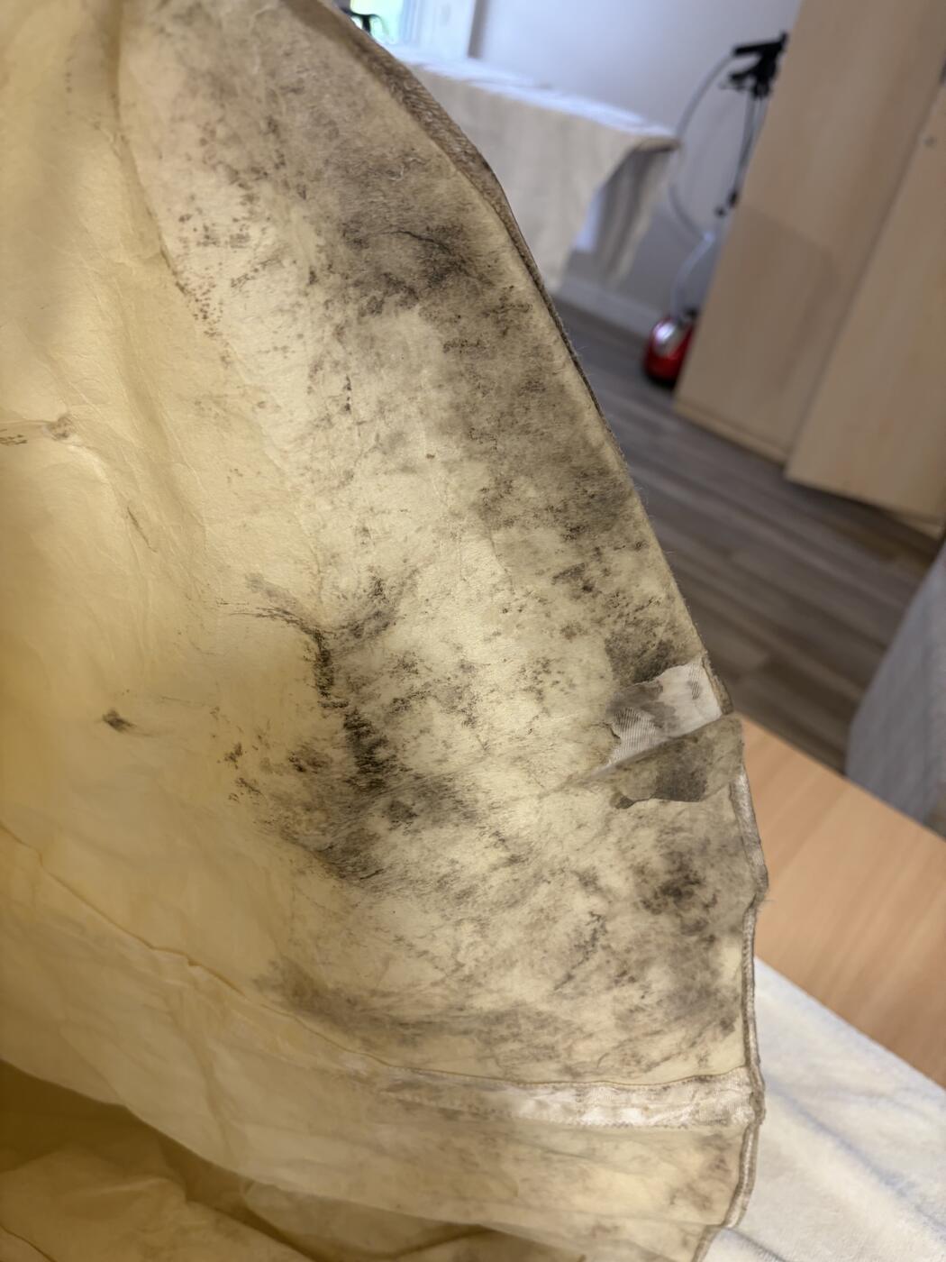 Dark mildew and soiling on the net underskirt of an antique wedding dress