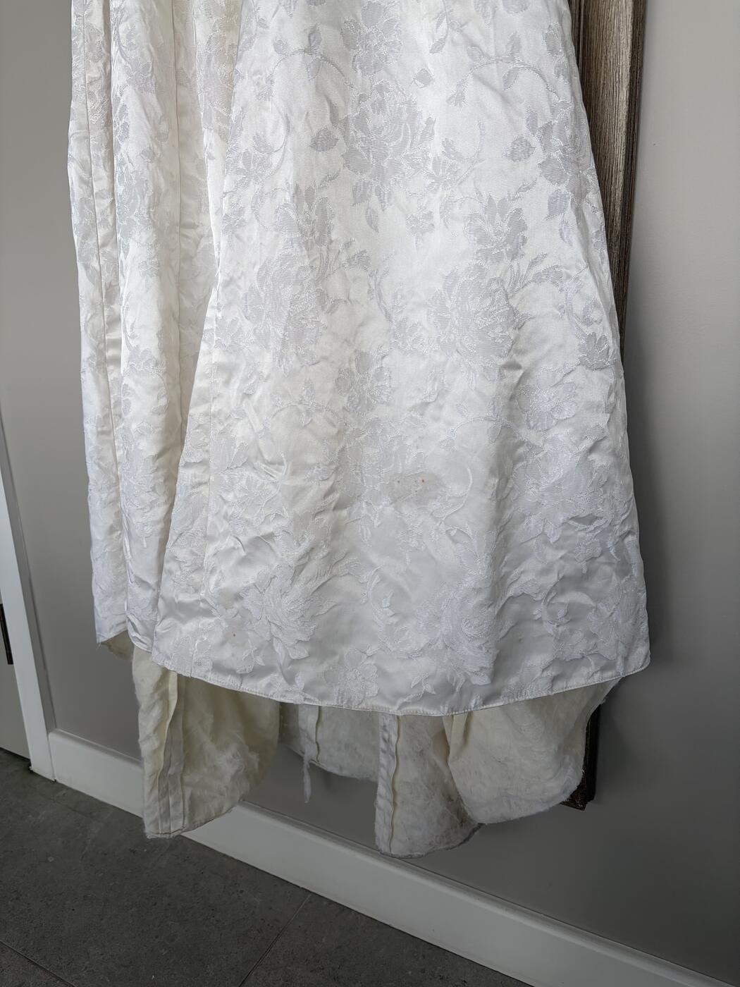 The same antique jacquard wedding dress hem after hand-cleaning